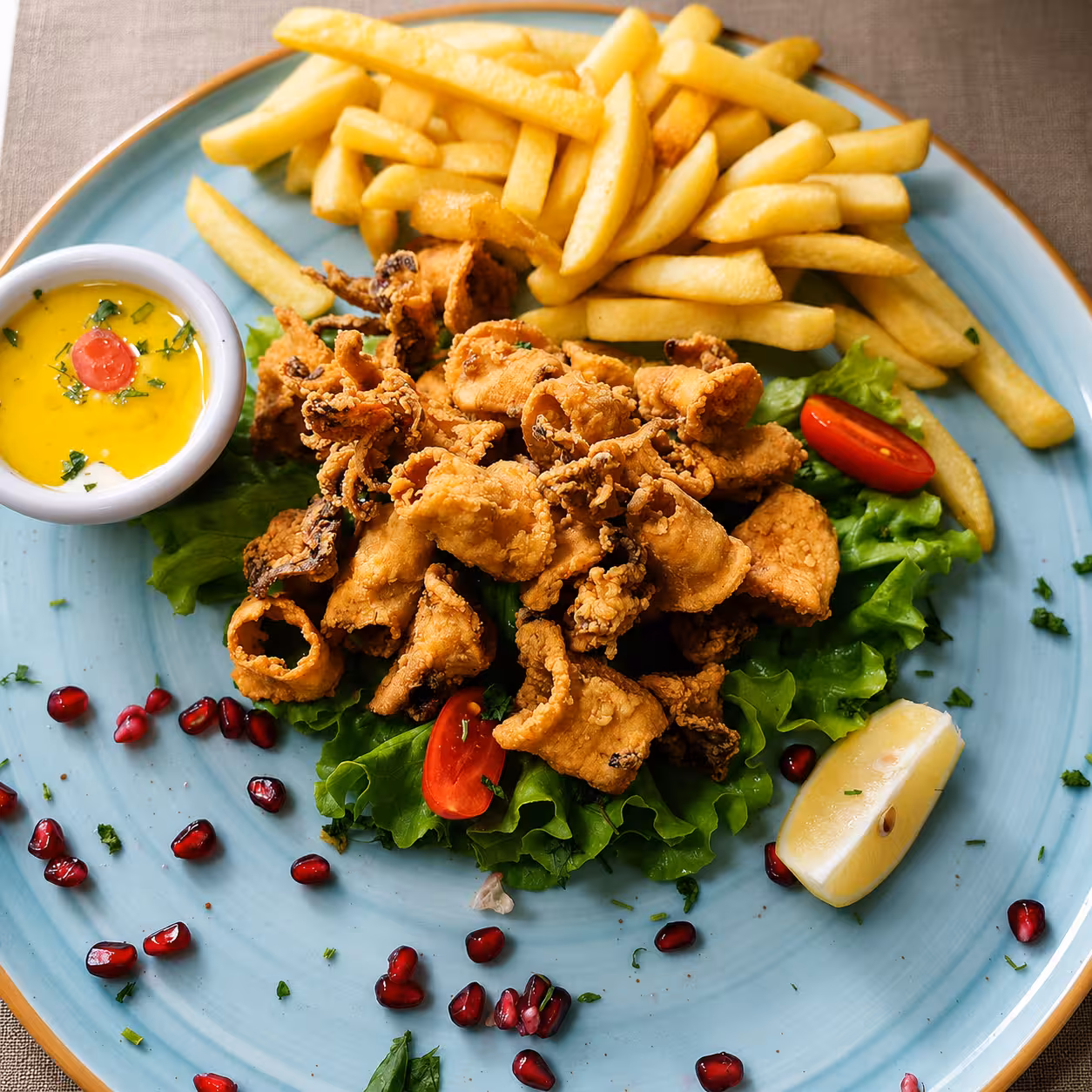 Fried calamari with fries and pomegranate